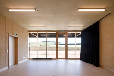 Miniature Location salle Chablis (Yonne) - Le Kimmeridgien #4 Un comptoir en béton dans un espace intérieur minimaliste avec sol en béton, murs texturés et grande porte vitrée.