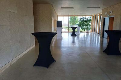 Paysage rural avec des champs cultivés, une maison isolée et une forêt en arrière-plan sous un ciel bleu.