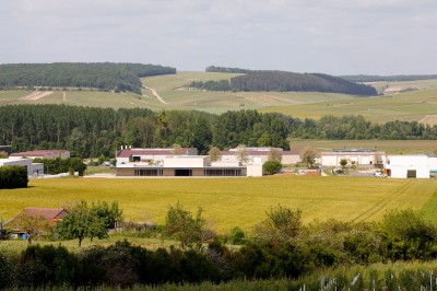 Miniature Location salle Chablis (Yonne) - Le Kimmeridgien #3 Paysage rural avec des champs cultivés, une maison isolée et une forêt en arrière-plan sous un ciel bleu.