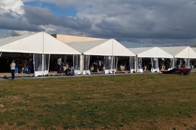 Plateau en bois garni de charcuteries variées, tranches de légumes et herbes fraîches, présenté sur une table blanche.