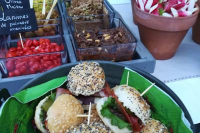 Bagels au sésame garnis de fromage frais, de légumes verts et d'herbes, disposés sur un plateau.