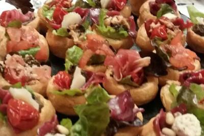 Bagels au sésame garnis de fromage frais, de légumes verts et d'herbes, disposés sur un plateau.