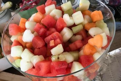 Bagels au sésame garnis de fromage frais, de légumes verts et d'herbes, disposés sur un plateau.