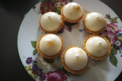 Bagels au sésame garnis de fromage frais, de légumes verts et d'herbes, disposés sur un plateau.