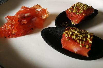 Bagels au sésame garnis de fromage frais, de légumes verts et d'herbes, disposés sur un plateau.