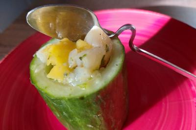 Bagels au sésame garnis de fromage frais, de légumes verts et d'herbes, disposés sur un plateau.