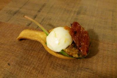 Bagels au sésame garnis de fromage frais, de légumes verts et d'herbes, disposés sur un plateau.