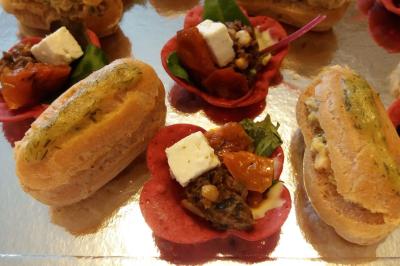 Bagels au sésame garnis de fromage frais, de légumes verts et d'herbes, disposés sur un plateau.