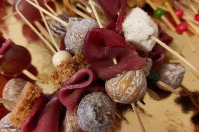 Assortiment de bouchées apéritives variées, incluant sushis, toasts et mini-brochettes, présenté sur un plateau.