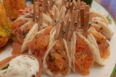 Assortiment de bouchées apéritives variées, incluant sushis, toasts et mini-brochettes, présenté sur un plateau.