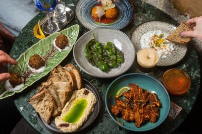Table sombre avec des verres à vin, une assiette de nourriture et un seau à champagne, éclairée par des bougies.