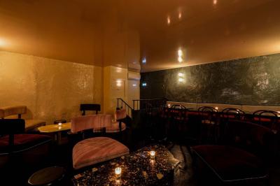 Table sombre avec des verres à vin, une assiette de nourriture et un seau à champagne, éclairée par des bougies.