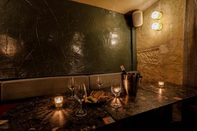 Table sombre avec des verres à vin, une assiette de nourriture et un seau à champagne, éclairée par des bougies.