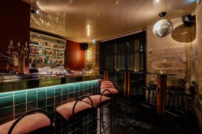 Table sombre avec des verres à vin, une assiette de nourriture et un seau à champagne, éclairée par des bougies.