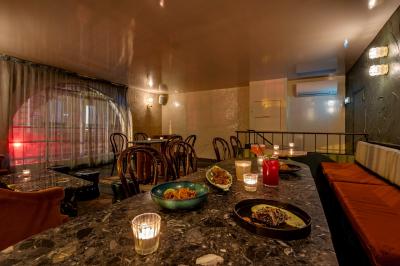 Table sombre avec des verres à vin, une assiette de nourriture et un seau à champagne, éclairée par des bougies.