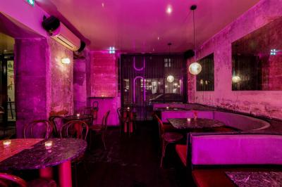 Table sombre avec des verres à vin, une assiette de nourriture et un seau à champagne, éclairée par des bougies.