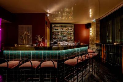 Table sombre avec des verres à vin, une assiette de nourriture et un seau à champagne, éclairée par des bougies.