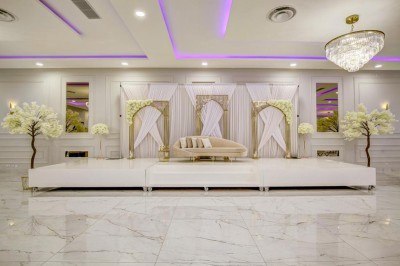 Parking vide entouré d'arbres et de bâtiments sous un ciel bleu avec quelques nuages.