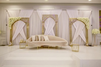 Parking vide entouré d'arbres et de bâtiments sous un ciel bleu avec quelques nuages.