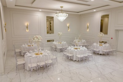 Parking vide entouré d'arbres et de bâtiments sous un ciel bleu avec quelques nuages.