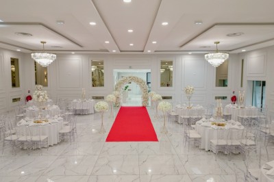 Parking vide entouré d'arbres et de bâtiments sous un ciel bleu avec quelques nuages.