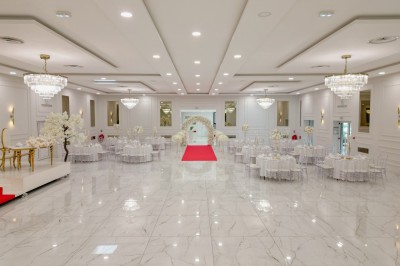 Parking vide entouré d'arbres et de bâtiments sous un ciel bleu avec quelques nuages.