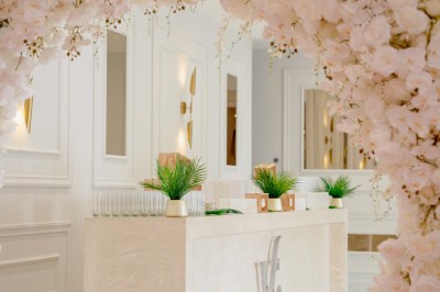 Parking vide entouré d'arbres et de bâtiments sous un ciel bleu avec quelques nuages.