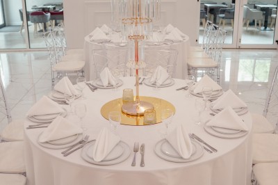 Parking vide entouré d'arbres et de bâtiments sous un ciel bleu avec quelques nuages.