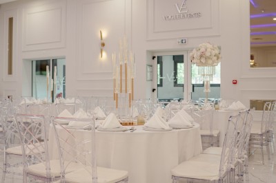 Parking vide entouré d'arbres et de bâtiments sous un ciel bleu avec quelques nuages.