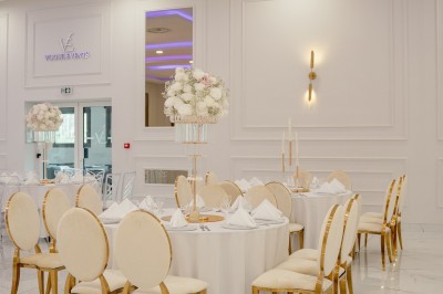 Parking vide entouré d'arbres et de bâtiments sous un ciel bleu avec quelques nuages.