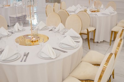 Parking vide entouré d'arbres et de bâtiments sous un ciel bleu avec quelques nuages.