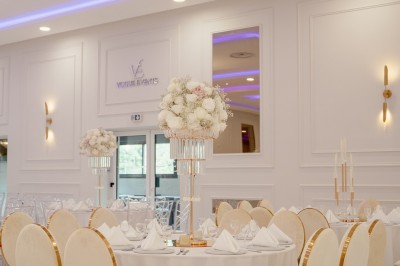 Parking vide entouré d'arbres et de bâtiments sous un ciel bleu avec quelques nuages.