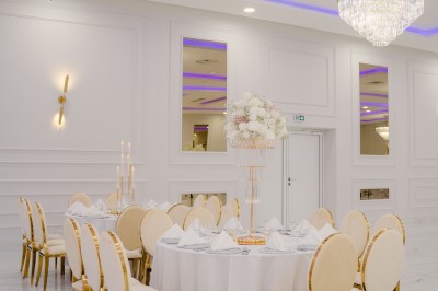 Parking vide entouré d'arbres et de bâtiments sous un ciel bleu avec quelques nuages.