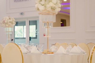 Parking vide entouré d'arbres et de bâtiments sous un ciel bleu avec quelques nuages.