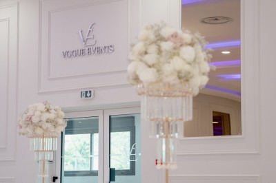 Parking vide entouré d'arbres et de bâtiments sous un ciel bleu avec quelques nuages.