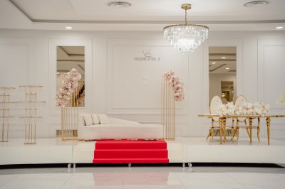 Parking vide entouré d'arbres et de bâtiments sous un ciel bleu avec quelques nuages.