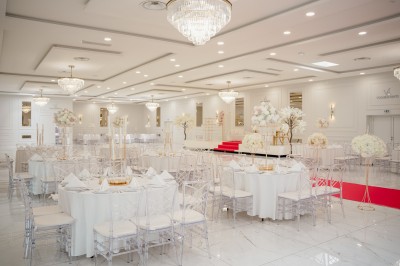 Parking vide entouré d'arbres et de bâtiments sous un ciel bleu avec quelques nuages.