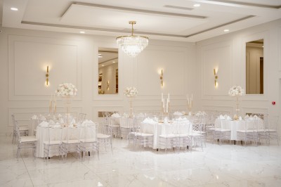 Parking vide entouré d'arbres et de bâtiments sous un ciel bleu avec quelques nuages.