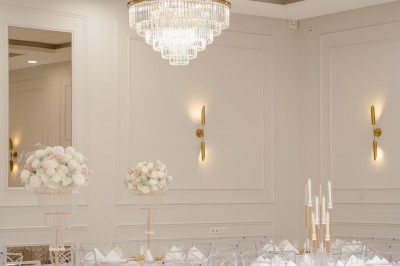 Parking vide entouré d'arbres et de bâtiments sous un ciel bleu avec quelques nuages.