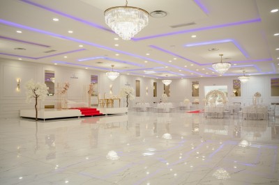 Parking vide entouré d'arbres et de bâtiments sous un ciel bleu avec quelques nuages.