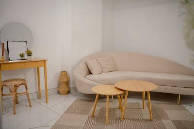 Parking vide entouré d'arbres et de bâtiments sous un ciel bleu avec quelques nuages.