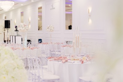 Parking vide entouré d'arbres et de bâtiments sous un ciel bleu avec quelques nuages.