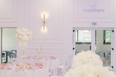 Parking vide entouré d'arbres et de bâtiments sous un ciel bleu avec quelques nuages.