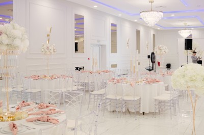 Parking vide entouré d'arbres et de bâtiments sous un ciel bleu avec quelques nuages.