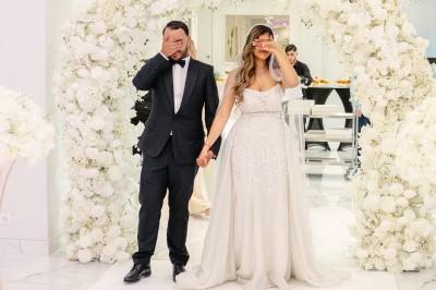 Parking vide entouré d'arbres et de bâtiments sous un ciel bleu avec quelques nuages.