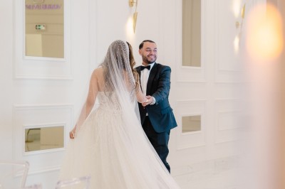 Parking vide entouré d'arbres et de bâtiments sous un ciel bleu avec quelques nuages.
