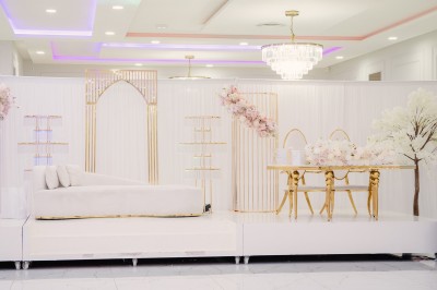 Parking vide entouré d'arbres et de bâtiments sous un ciel bleu avec quelques nuages.