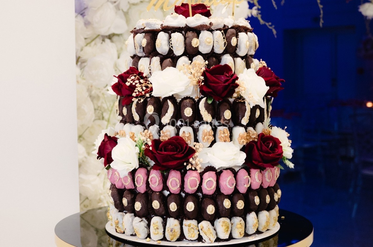 Pièce montée composée de chocolats, roses rouges et blanches, décorée pour une occasion festive.