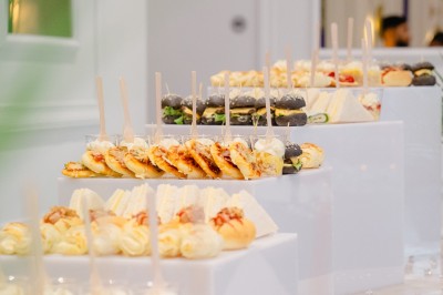 Parking vide entouré d'arbres et de bâtiments sous un ciel bleu avec quelques nuages.