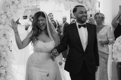 Parking vide entouré d'arbres et de bâtiments sous un ciel bleu avec quelques nuages.